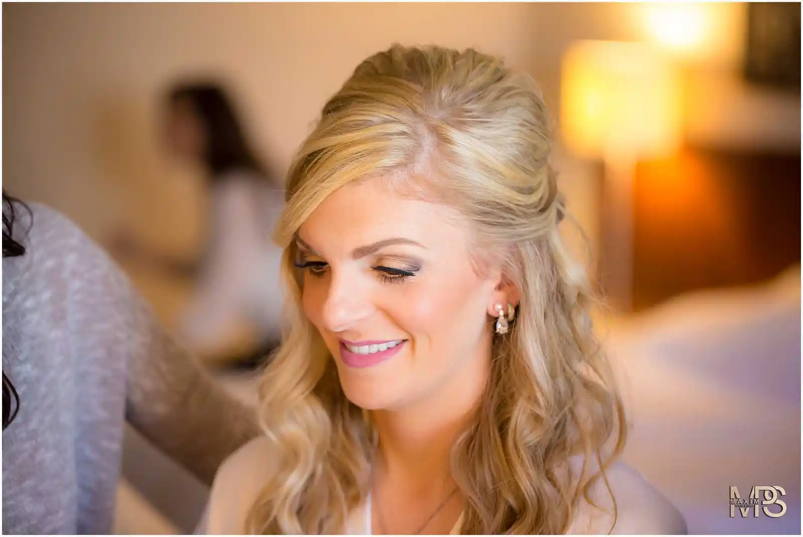 Happy blonde woman with elegant hairstyle smiling indoors at The Grand Covington KY