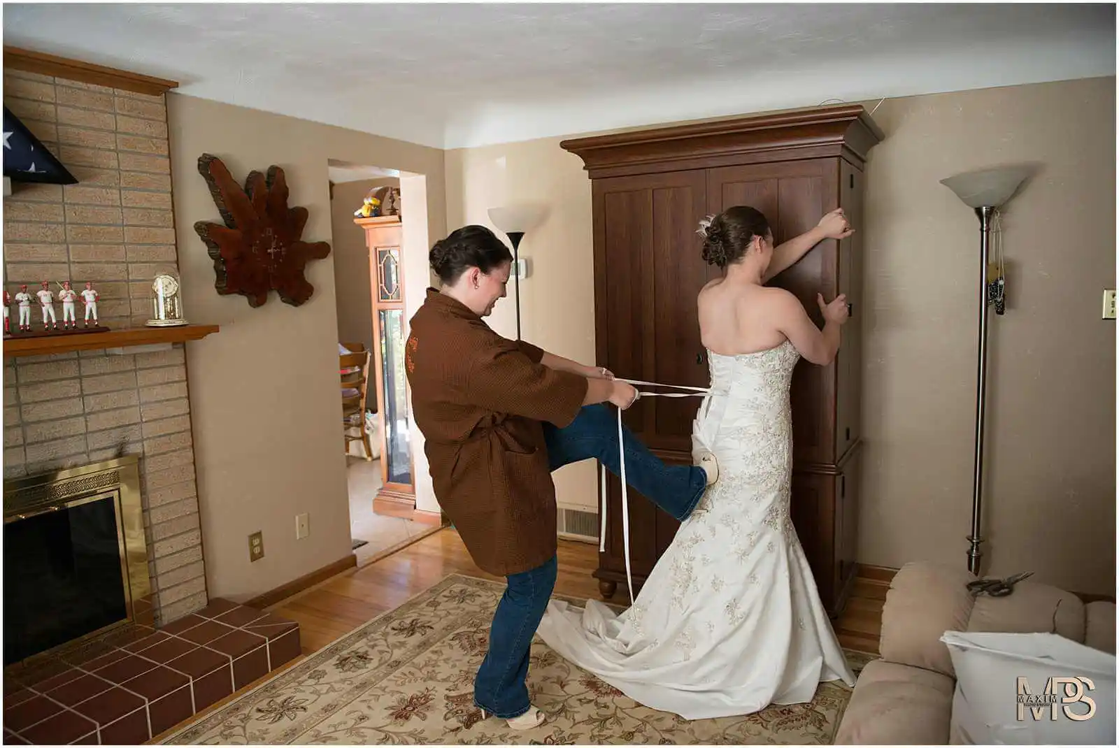 Bride preparing for wedding with assistance.