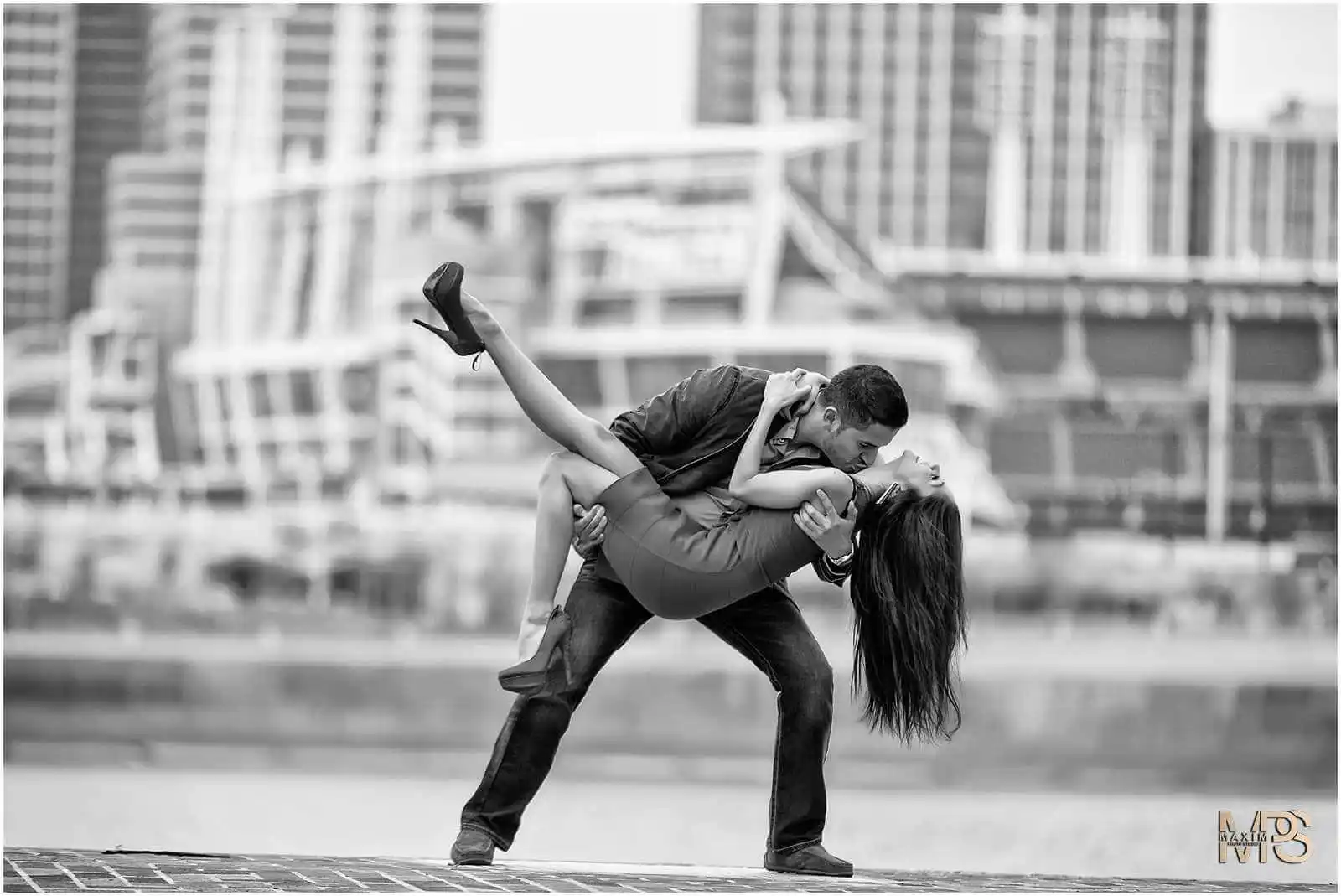 Elegant couple dancing in urban setting.