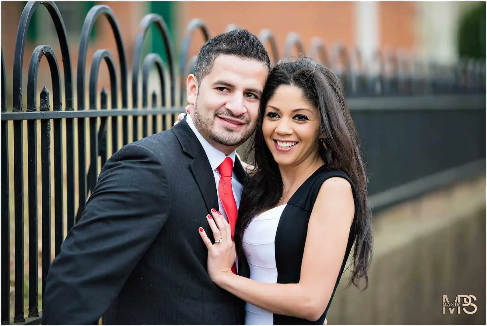 Elegant couple in portrait session smiling outdoors.