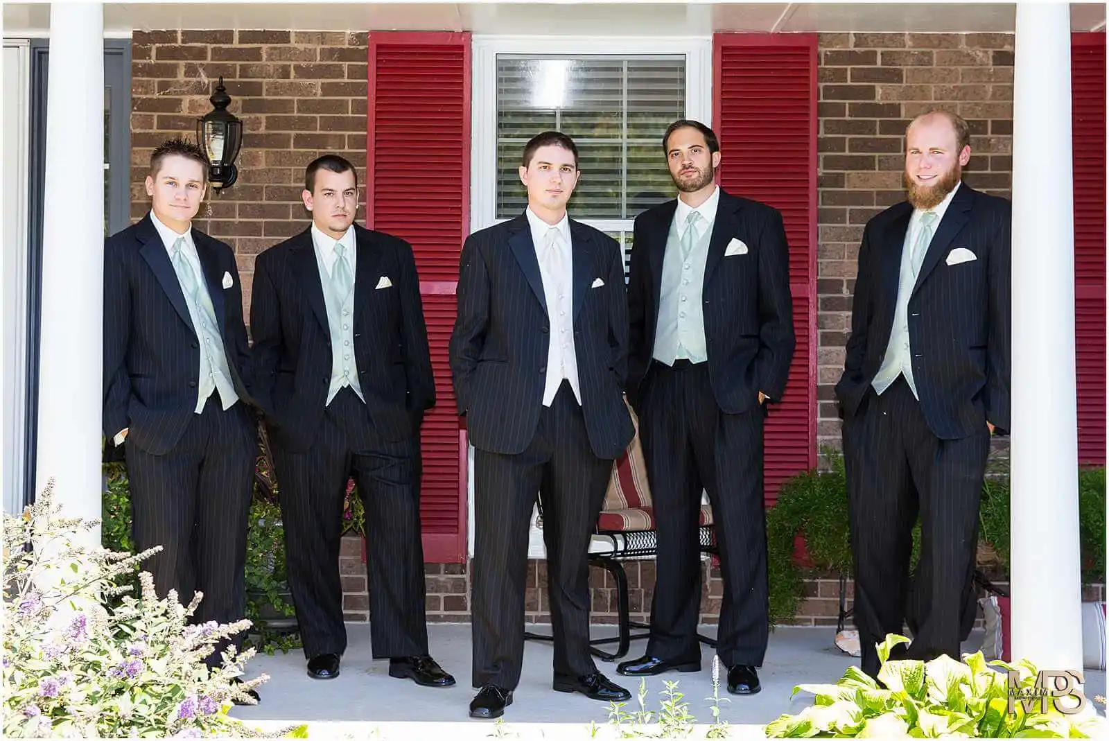 Elegant groomsmen posing in formal suits for a wedding.