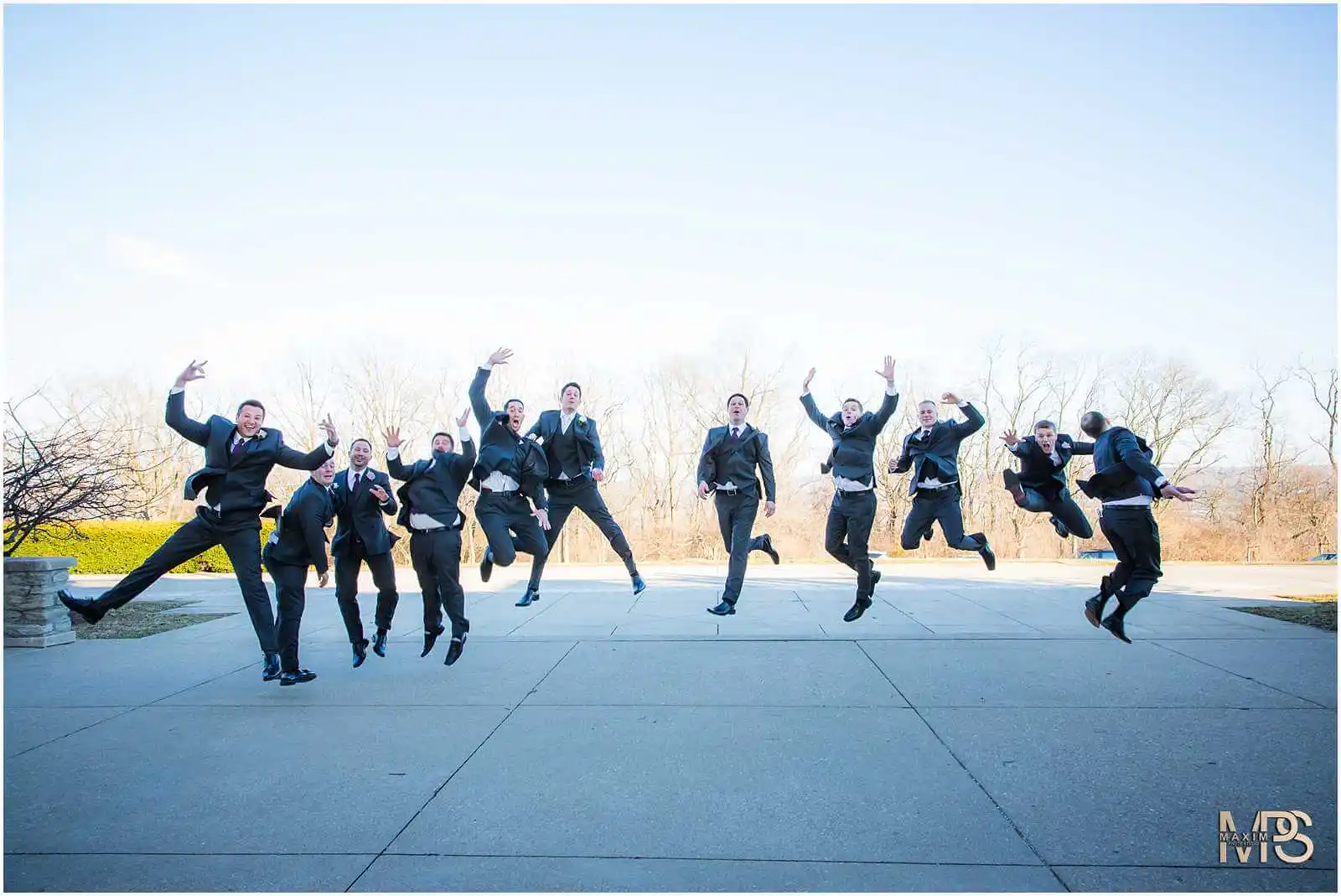 Energetic groomsmen jumping in celebration at a Cincinnati wedding.