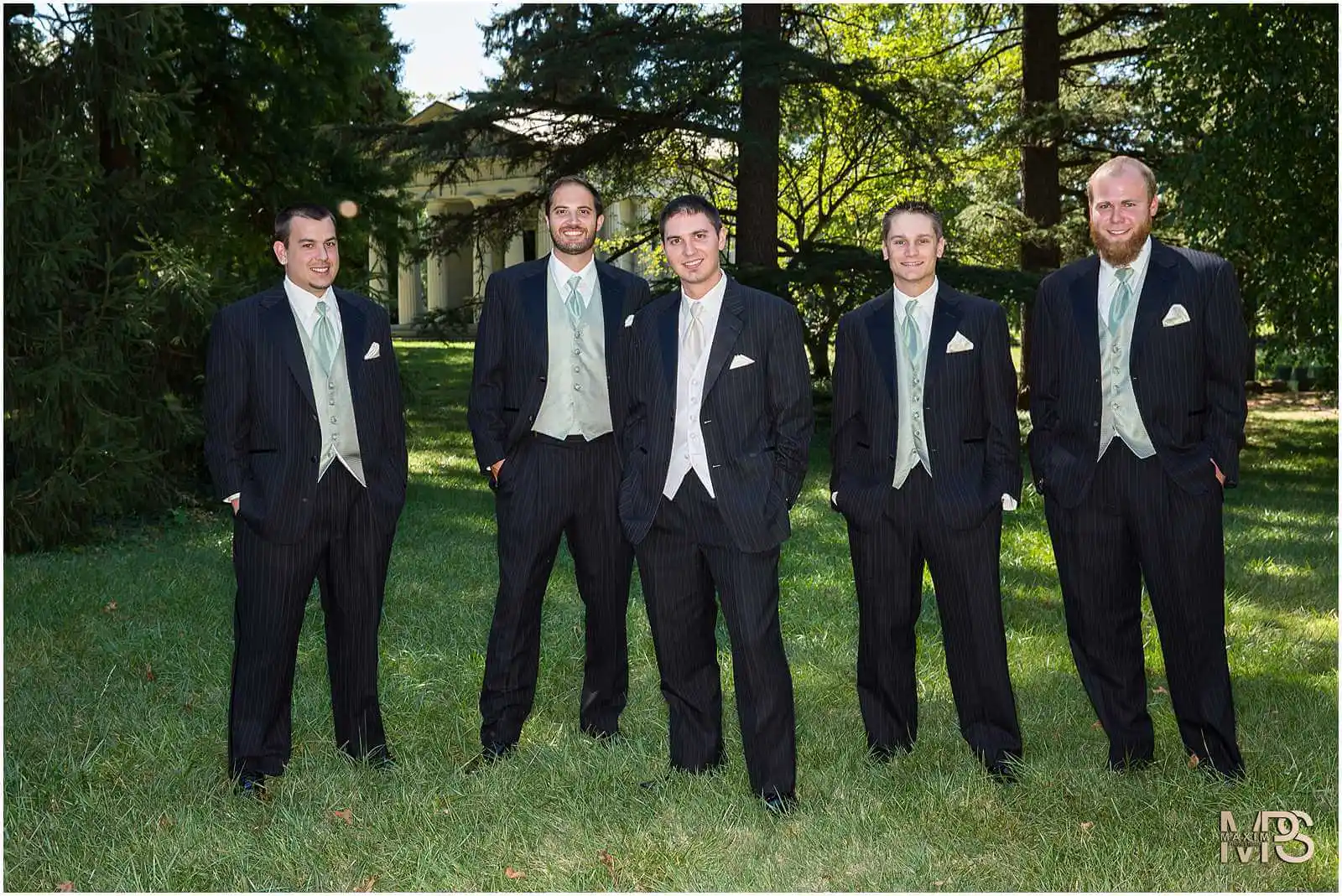 Elegant groomsmen posing outdoors in formal attire.
