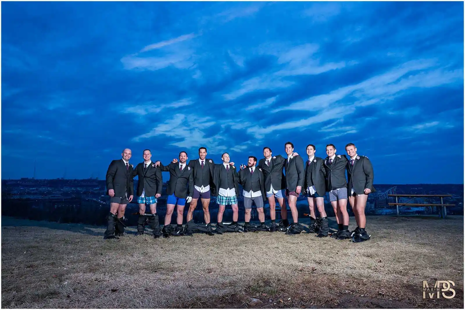 Men in underwear lined up with a scenic dusk skyline backdrop.
