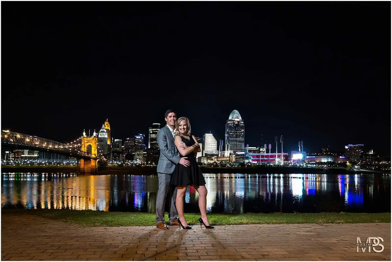 Romantic couple embracing during a nighttime cityscape photoshoot.
