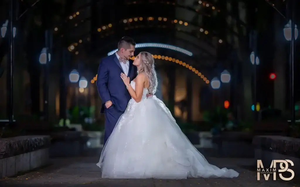 Bride and groom embrace at illuminated Cincinnati Club fall wedding.