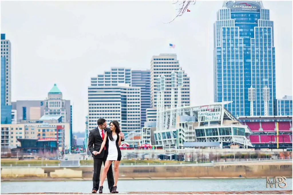 Loving couple embraces during cityscape photoshoot with skyscrapers.