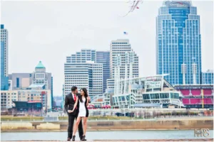 Loving couple embraces during cityscape photoshoot with skyscrapers.