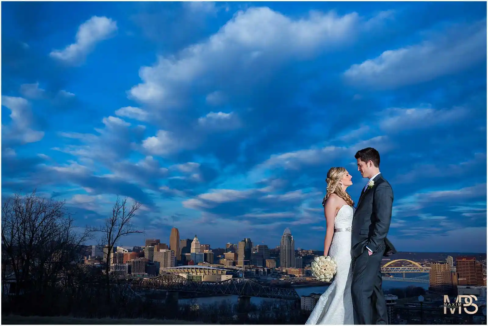 Newlyweds sharing a moment with a striking cityscape in Covington, KY.