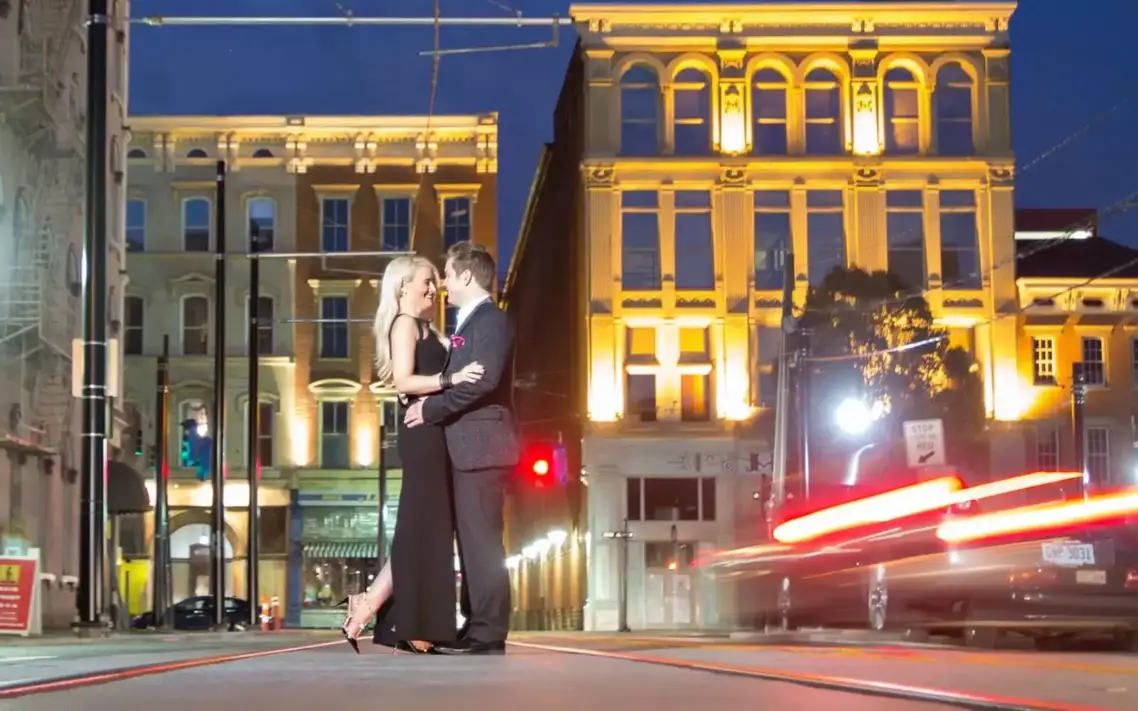 Couple engagement photo with nighttime city lights in Cincinnatis OTR district.